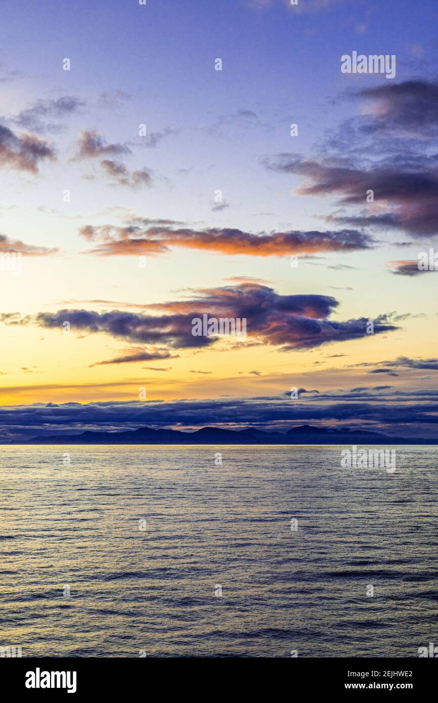 Seltsame Gestalt einer fliegenden Figur oder eines Engels bei Sonnenuntergang über der nordwestlichen Pazifikküste bei Prince of Wales Island, Alaska, USA - von einem Kreuzfahrtschiff aus gesehen. Stockfoto