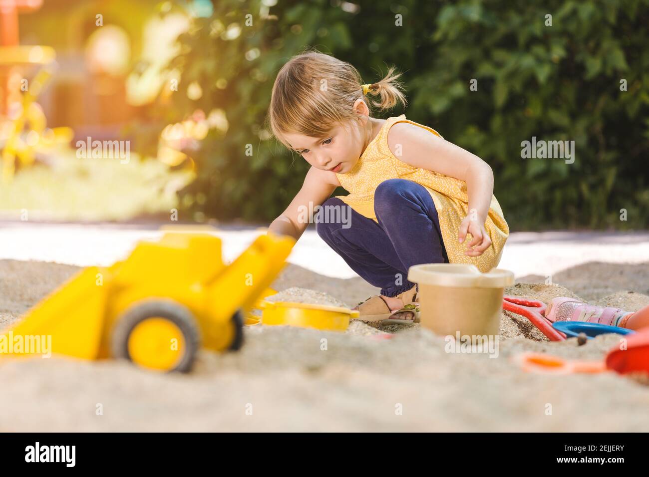 Kleines Mädchen mit viel Spaß mit ihrem Spielzeug spielen in der Sandbox Stockfoto