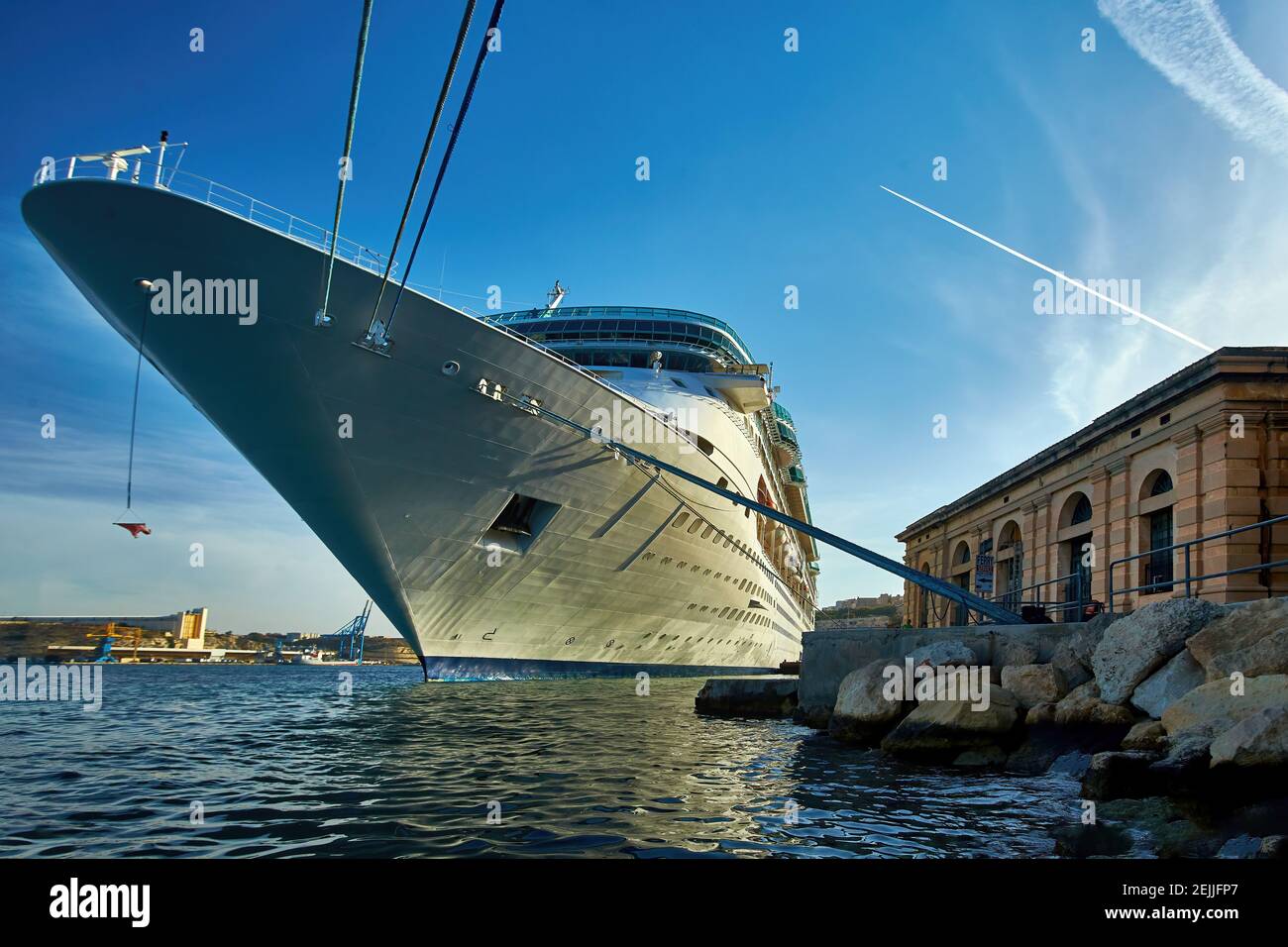 Ozeandampfer im Hafen von altem Valletta. Blick vom Wasserstand auf riesiges, weißes Schiff gegen die Sonne. Malta. Stockfoto