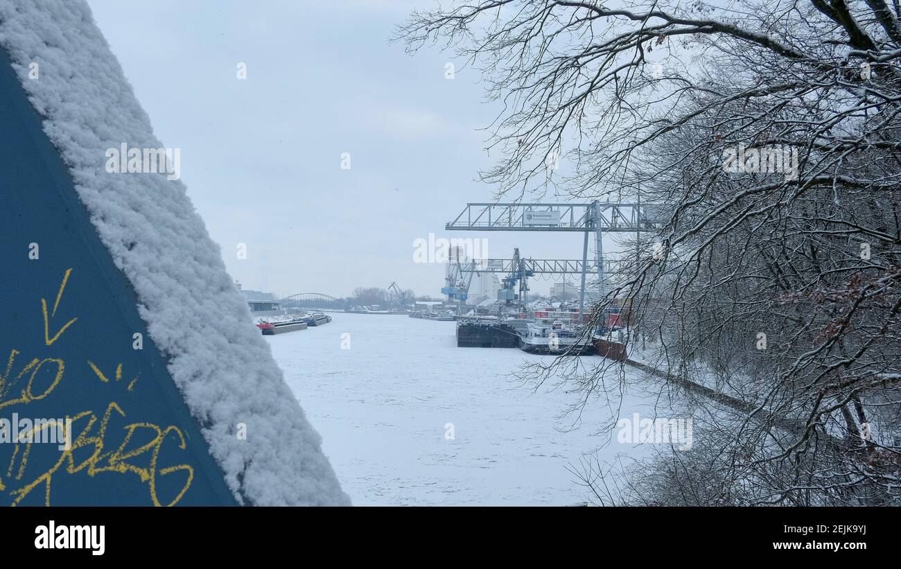 Braunschweig, Deutschland. Februar 2021, 12th. Blick über den gefrorenen Mittelland-Kanal zum Hafen von Braunschweig. Im Binnenhafen der ehemaligen Hansestadt sind seit mehreren Tagen zahlreiche Schiffe vertäut, weil der Mittellandkanal zugefroren ist. Alle Eisbrecher wurden abberufen, um die Weser eisfrei zu halten. Quelle: Stefan Jaitner/dpa/Alamy Live News Stockfoto