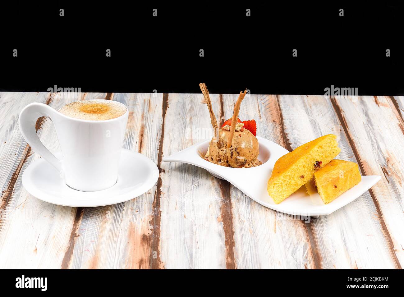 Tasse heißen Cappuccino Kaffee begleitet von einem Stück Kuchen und eine Kugel Zimtschokolade-Eis Stockfoto