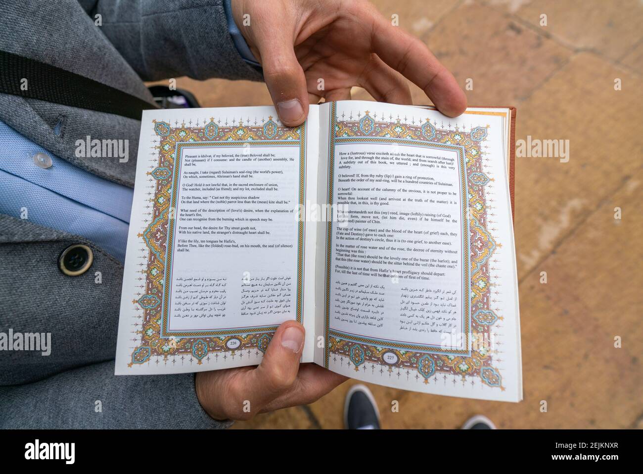 Shiraz, Iran - 04,14.2019: Mann mit offenem Buch des berühmten persischen Dichters Hafez Shirazi. Stockfoto