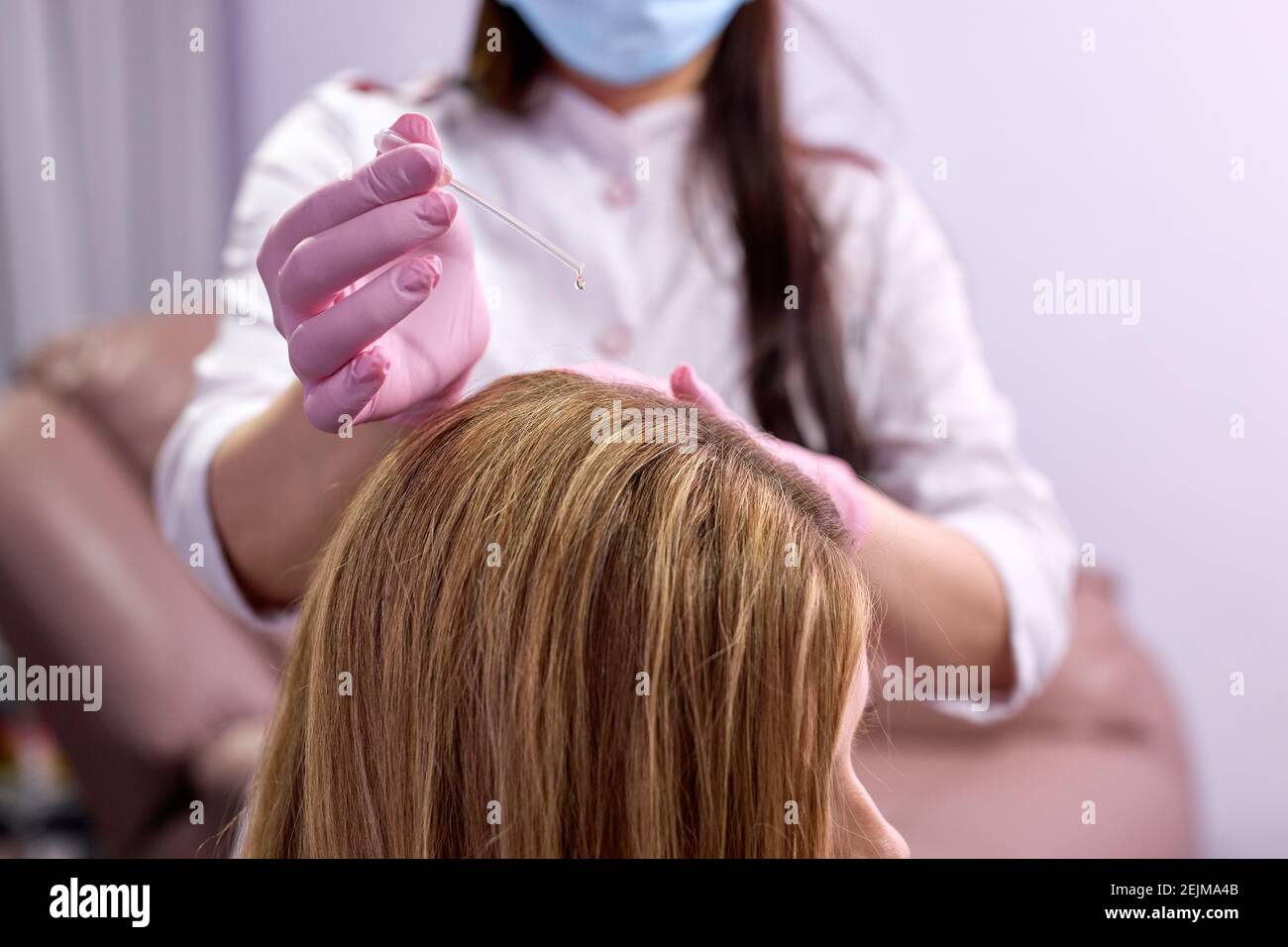 Kosmetologe Anwendung Serum auf den weiblichen Kopf, Vitamine in Frau Haut Kopf für Haarwachstum und gegen Schuppen in der Kosmetologie Klinik, Nahaufnahme. Haare Stockfoto