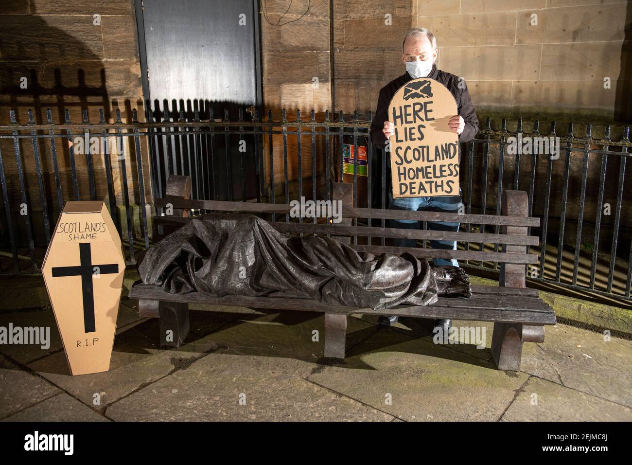Glasgow, Schottland, Großbritannien. Februar 2021, 22nd. Im Bild: Sean Clerkin - Scottish Pächters Organization, mit einem grabsteinförmigen Plakat mit der Aufschrift: „HIER LIEGT DER OBDACHLOSE IN SCOTLANDS“. Heute, am 23rd. Februar 21, hat die schottische Regierung die Zahl der Obdachlosen-Todesfälle 3 Tage früher freigegeben, die um 11% höher sind als im letzten Jahr. Der Link https://www.nrscotland.gov.uk/news/2021/homeless-deaths-2019 zeigt den Artikel heute. Quelle: Colin Fisher/Alamy Live News Stockfoto