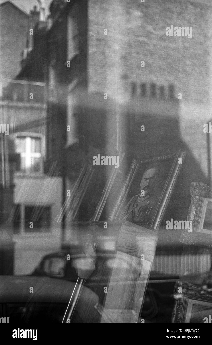 Großbritannien, West London, Notting Hill, 1973. Reflexionen in einem Schaufenster Verkauf von Antiquitäten auf Portobello Road. Stockfoto