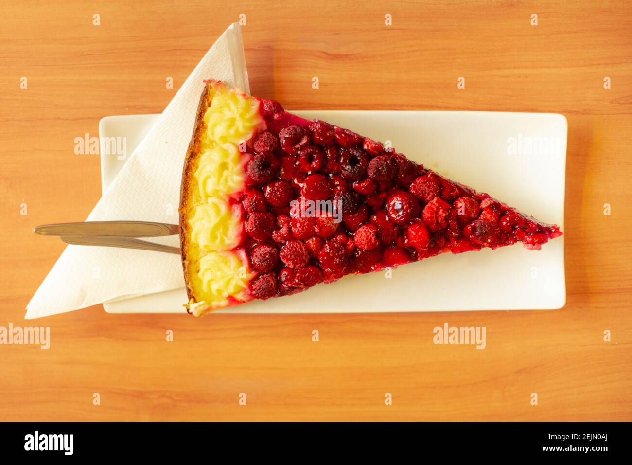 Stück Himbeerkuchen auf einem Holztisch in warm Sommersonne Stockfoto