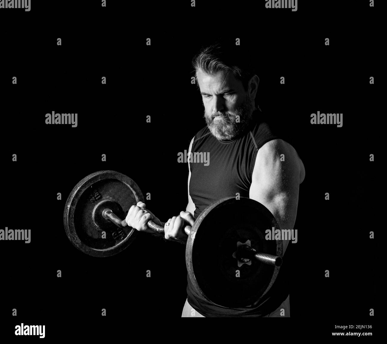 Dramatische Schwarz-Weiß-Foto von starken, aktiven, mittleren Alters Mann mit grauem Bart heben schwere Gewichte in Studio-Einstellung, 2 Drittel Profilansicht. Stockfoto
