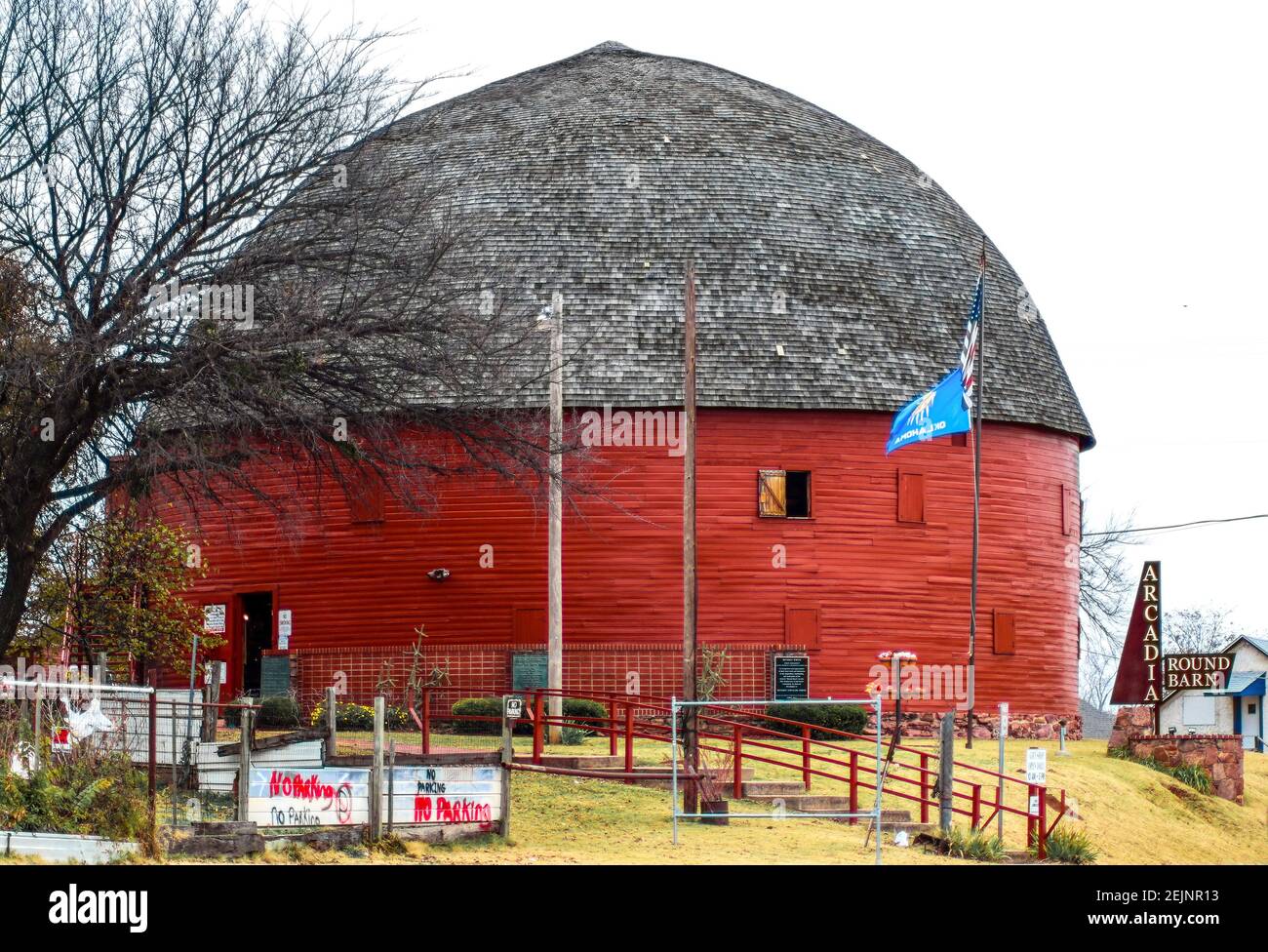 Arcadia Oklahoma 11 -13 - 2017 Wahrzeichen - altes Holz Big Red Round Barn und OK und USA Flaggen Stockfoto