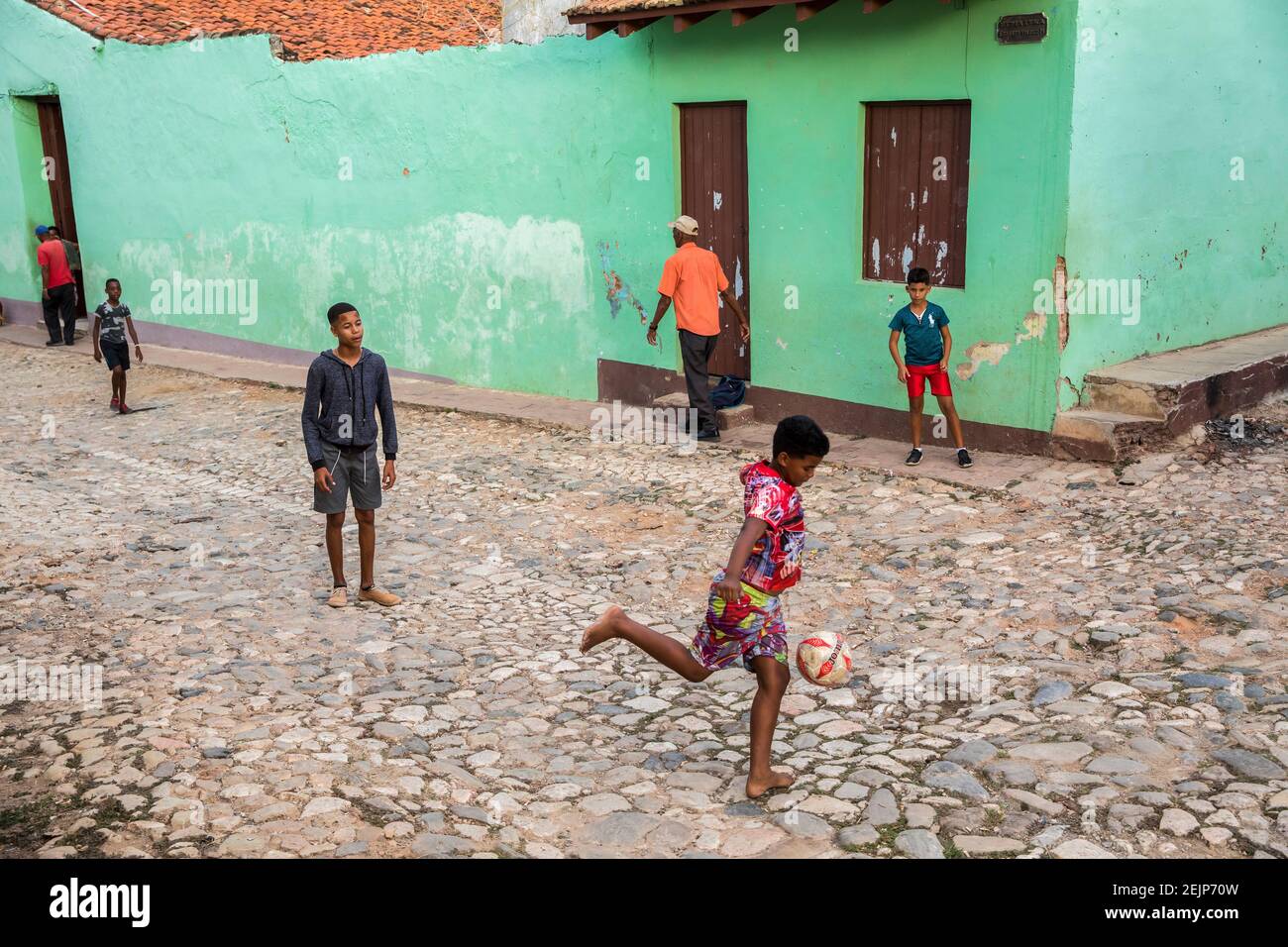 Kinder spielen Fußball auf einer gepflasterten Straße in Trinidad, Kuba Stockfoto