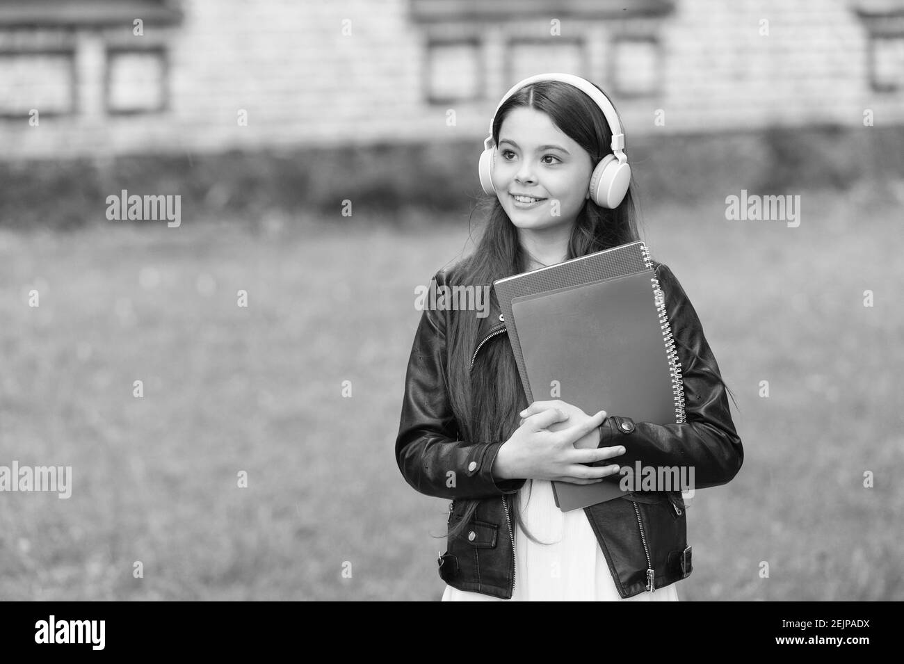 Schulmädchen hören Hörbücher auf dem Weg zur Schule, Audio-Unterricht Konzept. Stockfoto