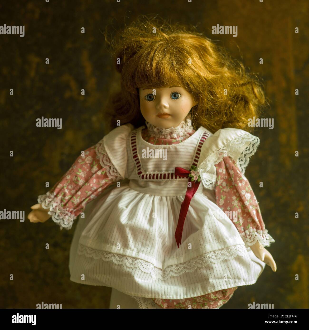 Porträt einer Vintage-Puppe mit einem schönen Kleid an Der braune Hintergrund Stockfoto