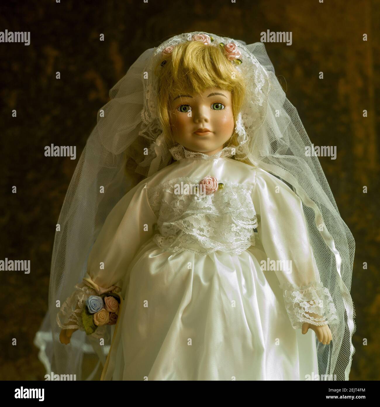 Nahaufnahme einer Vintage Puppe mit einer schönen Hochzeit Kleid auf dem braunen Hintergrund Stockfoto