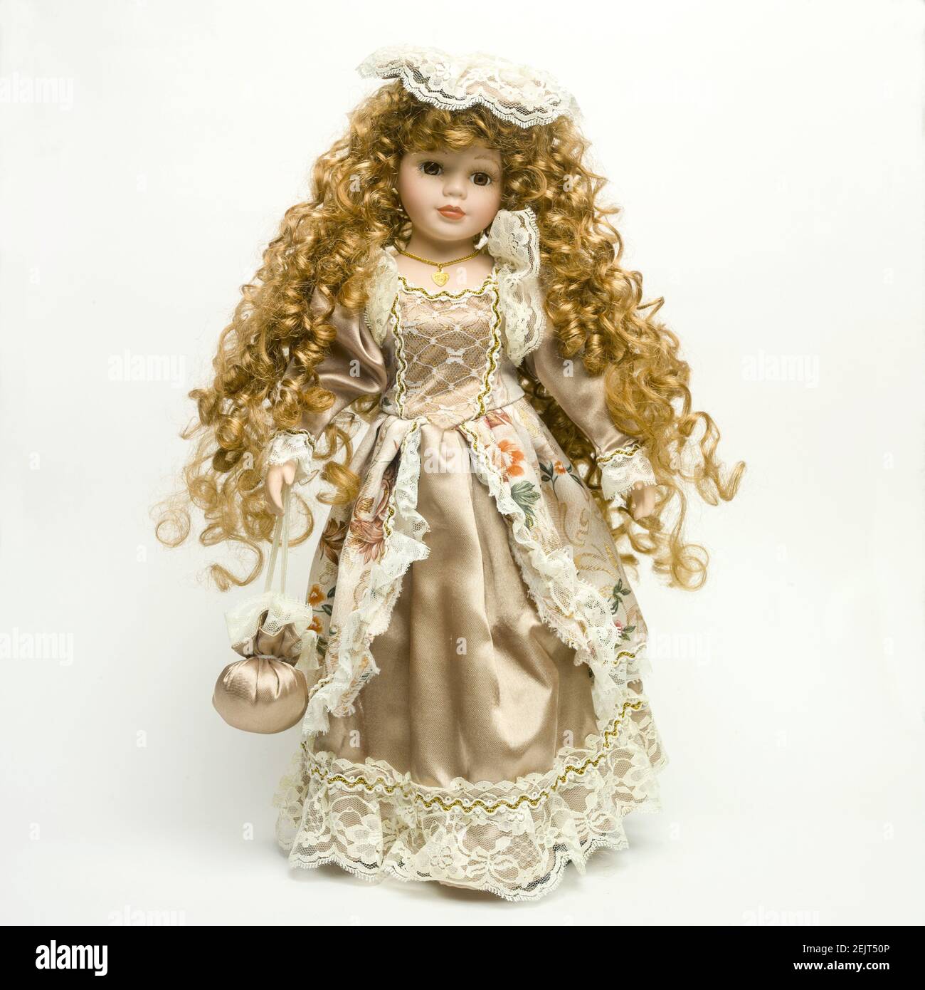 Vintage Puppe mit einem schönen Kleid und goldenen Strähnen auf Der weiße Hintergrund Stockfoto