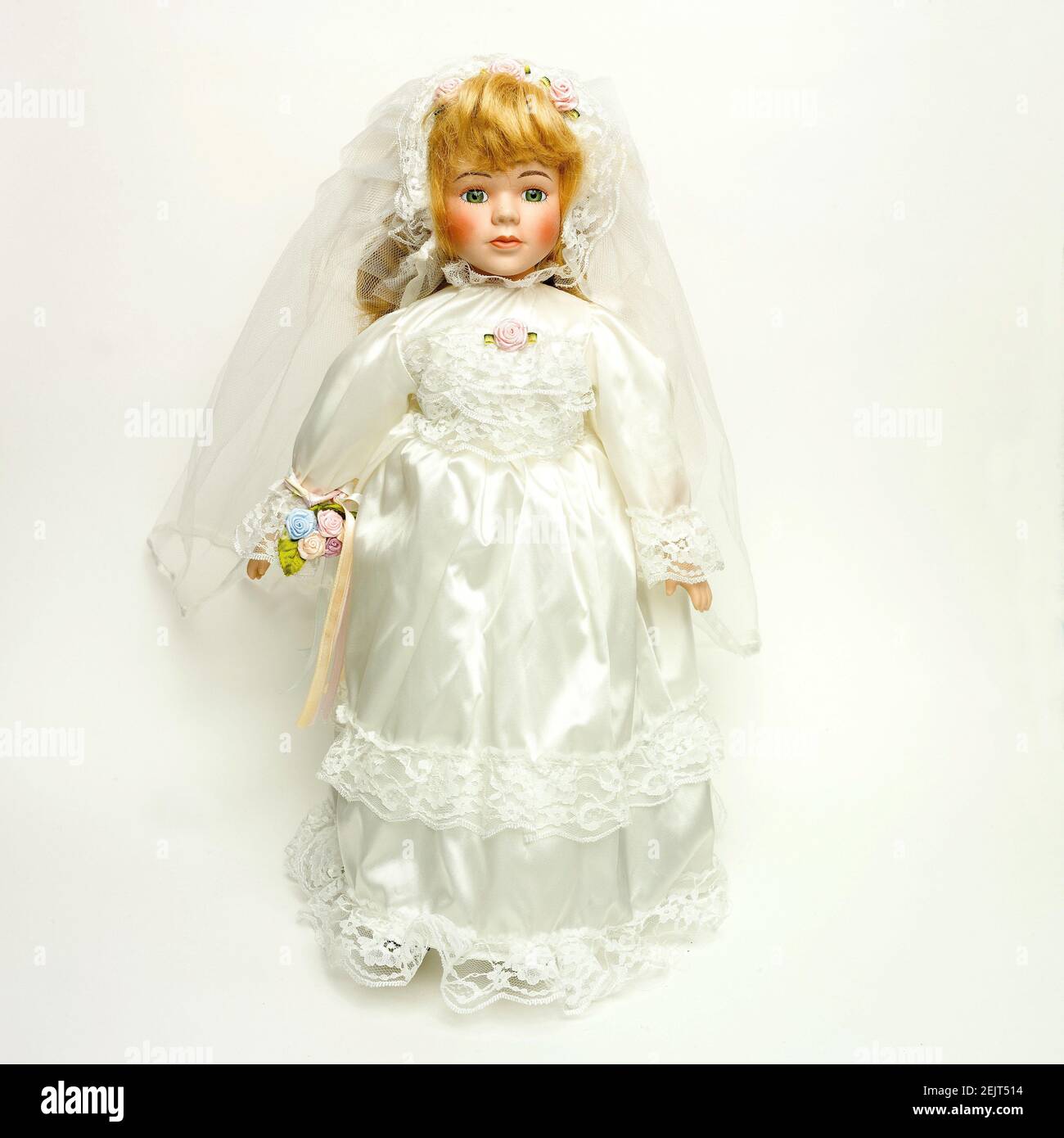 Vintage Puppe mit einem schönen Hochzeitskleid auf dem weißen Hintergrund Stockfoto