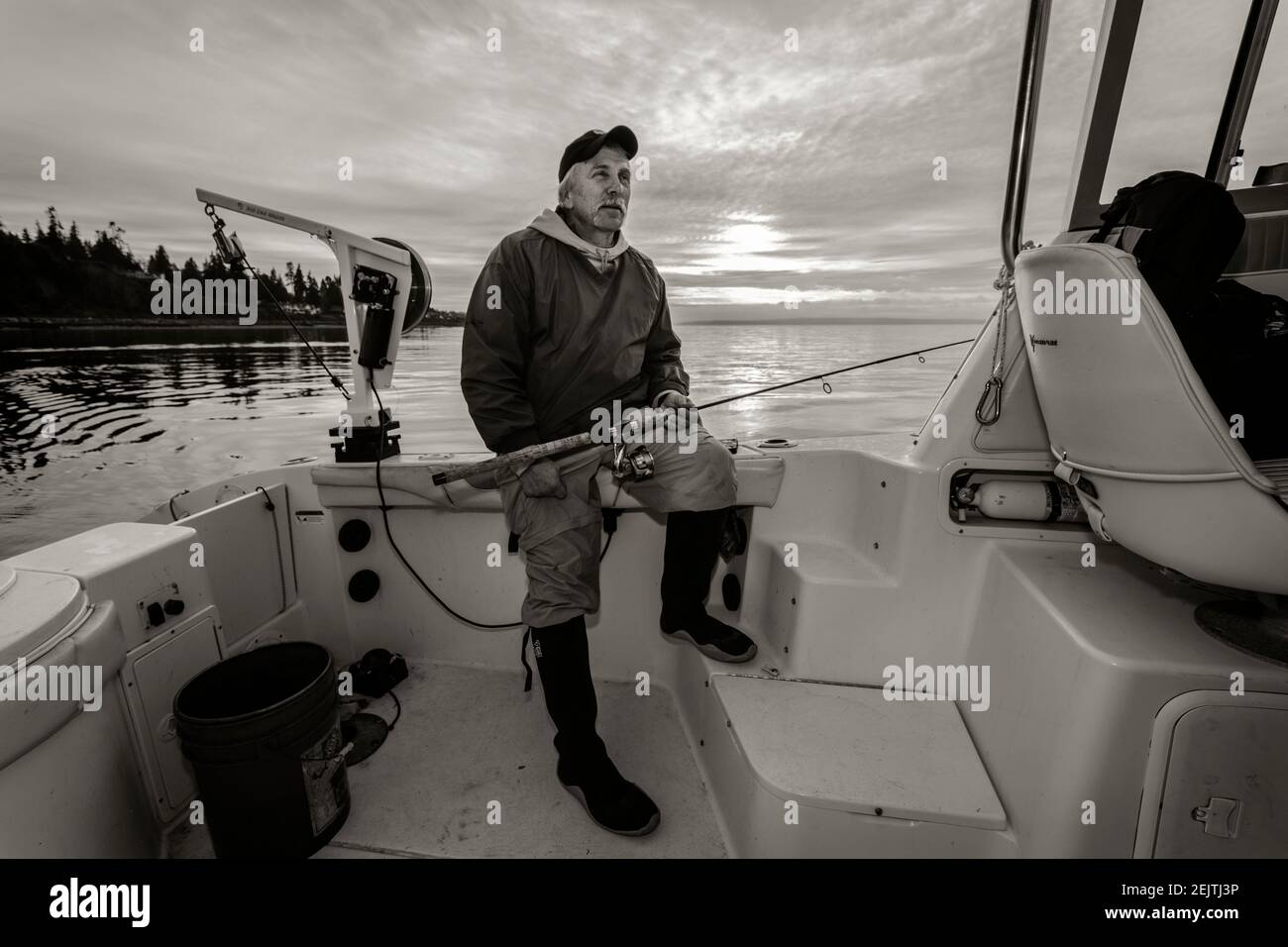 WA20086-00-BW WASHINGTON - Phil Russell nimmt einen Moment zum Entspannen, während Tintenfisch Angeln auf dem Puget Sound. Stockfoto