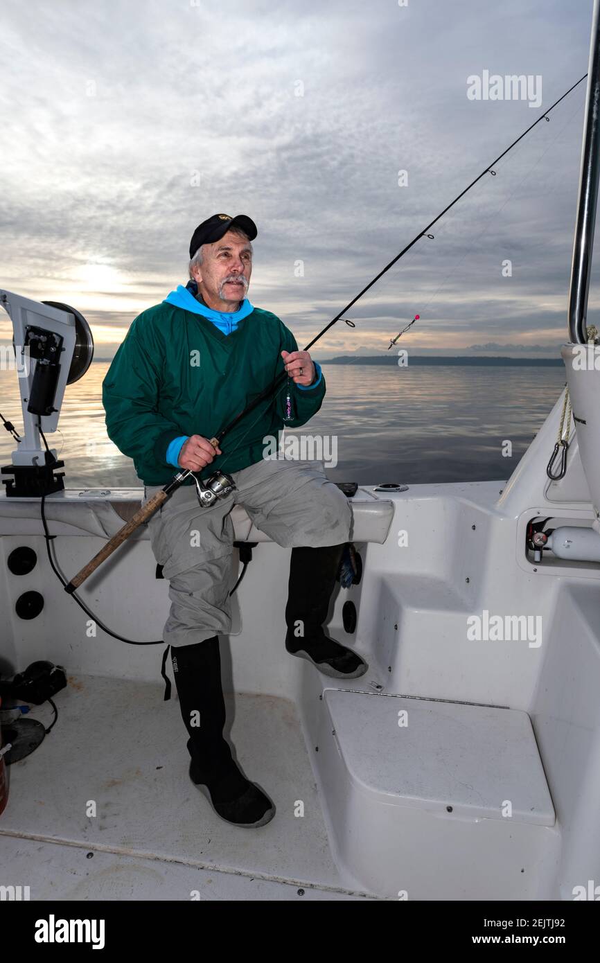 WA20087-00...... WASHINGTON - Phil Russell nimmt einen Moment zum Entspannen, während Tintenfisch Angeln auf dem Puget Sound. Stockfoto