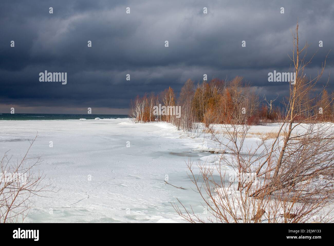 Ein Wintersturm nähert sich den Ufern der Southern Georgian Bay in Lighthouse Point, Collingwood. Eis erstreckt sich über die Bucht mit düsteren, bedrohlichen Wolke Stockfoto