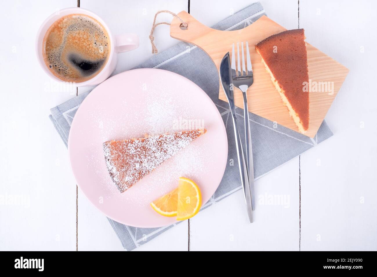 Zwei Stück Kuchen auf einem rosa Teller und ein Schneidebrett Stockfoto
