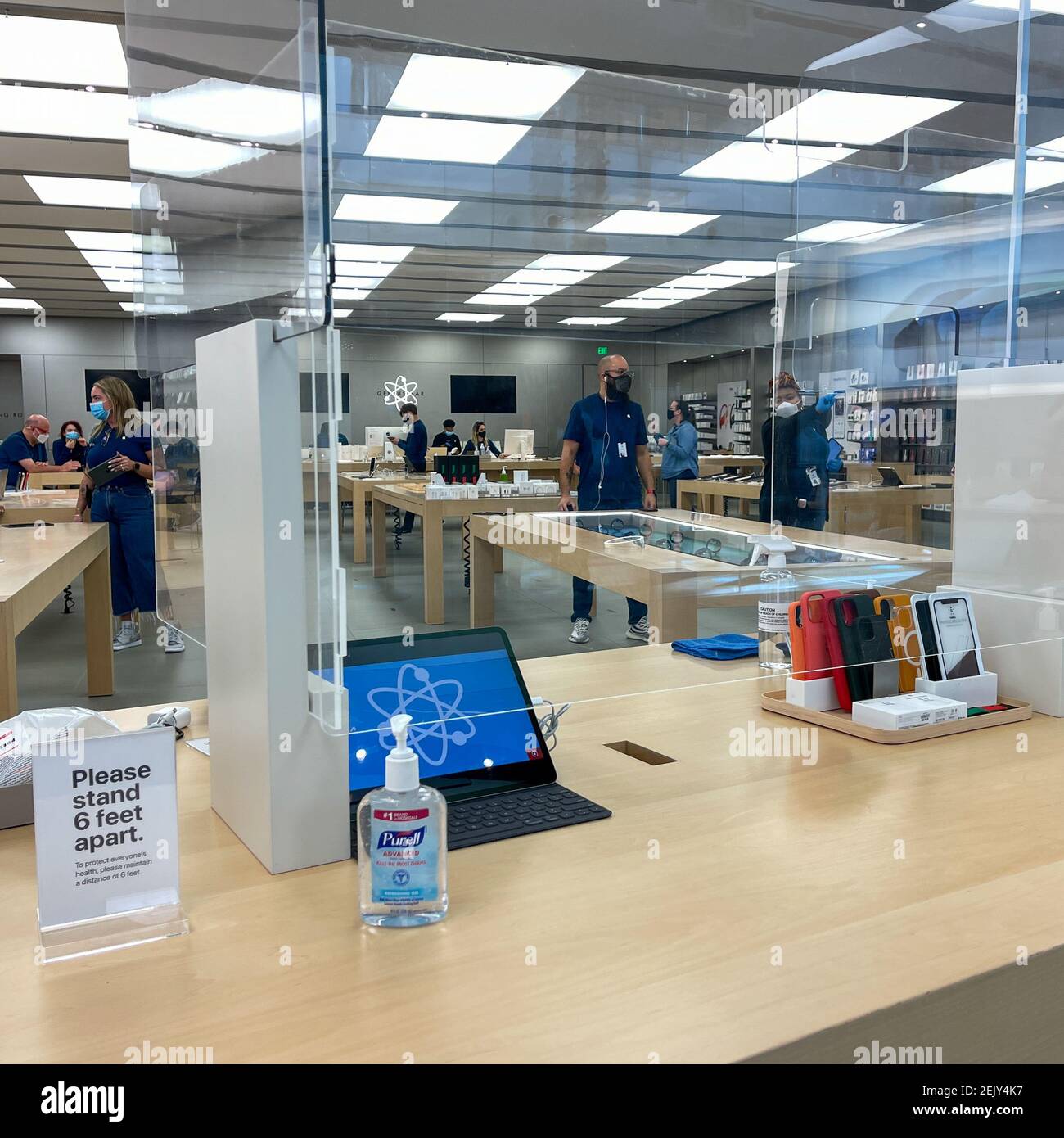 Orlando, FL USA - 5. Februar 2021: Apple-Mitarbeiter warten auf Kunden mit Plexiglas-Schilden zwischen der Woche mit Gesichtsmasken wegen der Coronavi Stockfoto