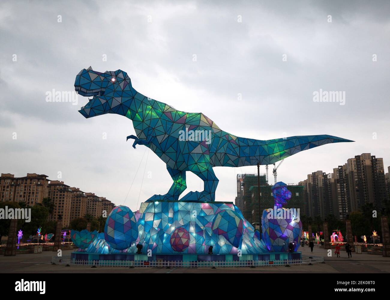 Ein riesiges Dinosaurierlicht erscheint auf einem Platz und fällt den vorbeiziehenden Bürgern der Stadt Changzhou, der Provinz Jiangsu in Ostchina, am 19. April 2020 auf. Stockfoto