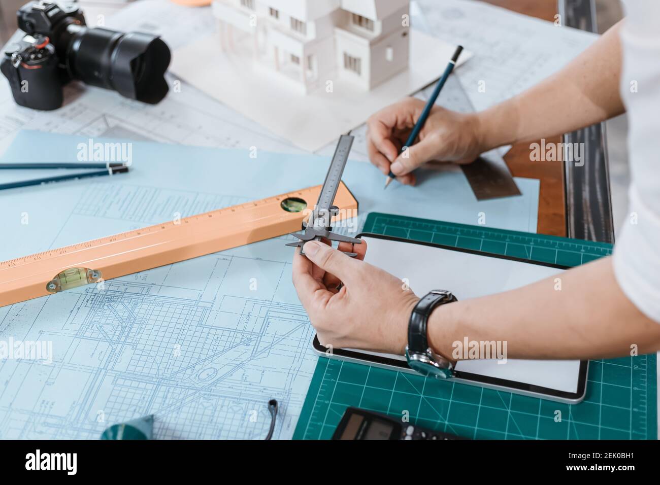 Engineering Hände halten Messschieber arbeiten und Überprüfung Zeichnung blaue Druckskala am Arbeitsplatz. Architektur, Ingenieurwesen, Wirtschaft und Bau Konz Stockfoto
