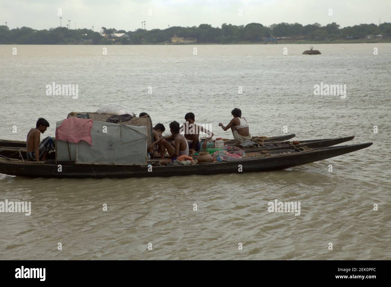 Männer, die mit Booten auf dem Hooghly River in Kalkutta, Westbengalen, Indien, schweben. Stockfoto