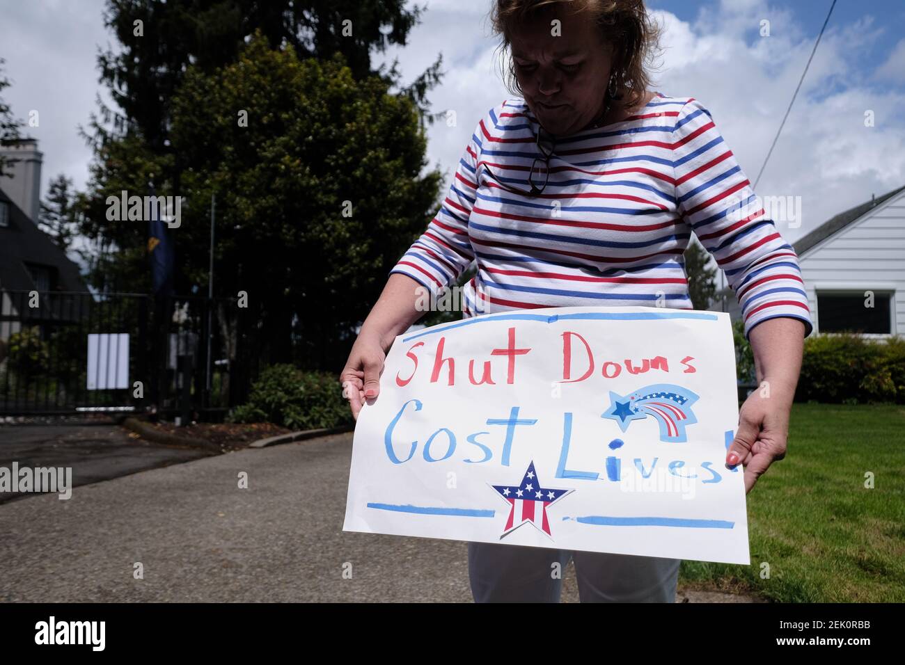 Eine Frau hält ein Schild, als sich Demonstranten am 25. April 2020 vor der Residenz von Gouverneur Kate Brown in Salem, Oregon, versammeln und fordern, dass die Beschränkungen für neuartige Coronaviren aufgehoben werden, damit die Menschen wieder zur Arbeit zurückkehren können. (Foto von Alex Milan Tracy/Sipa USA) Stockfoto