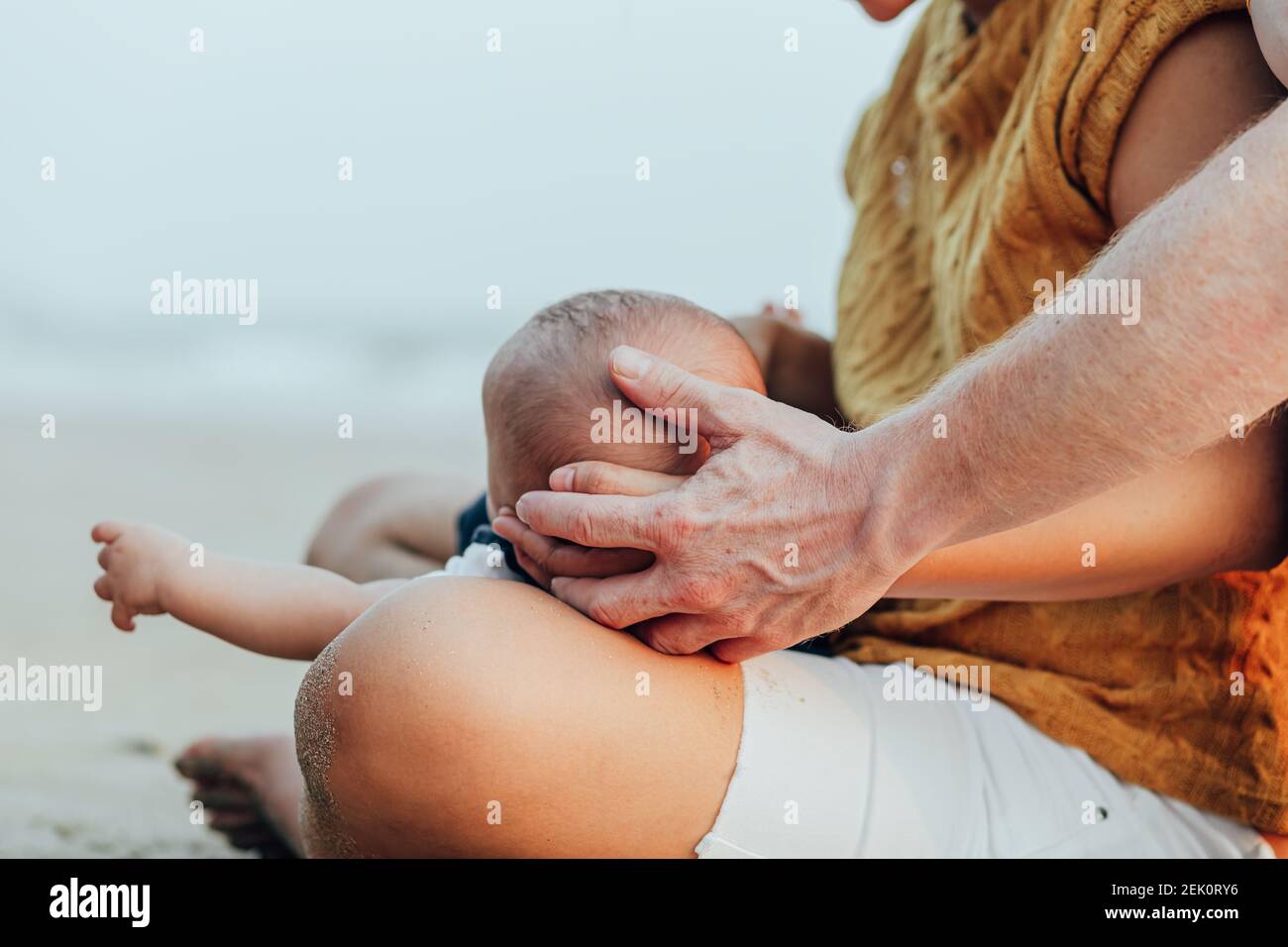 Glückliche Familie am Strand. Vater, Mutter und Baby haben Spaß im Sommerurlaub. Urlaubsreisekonzept Stockfoto