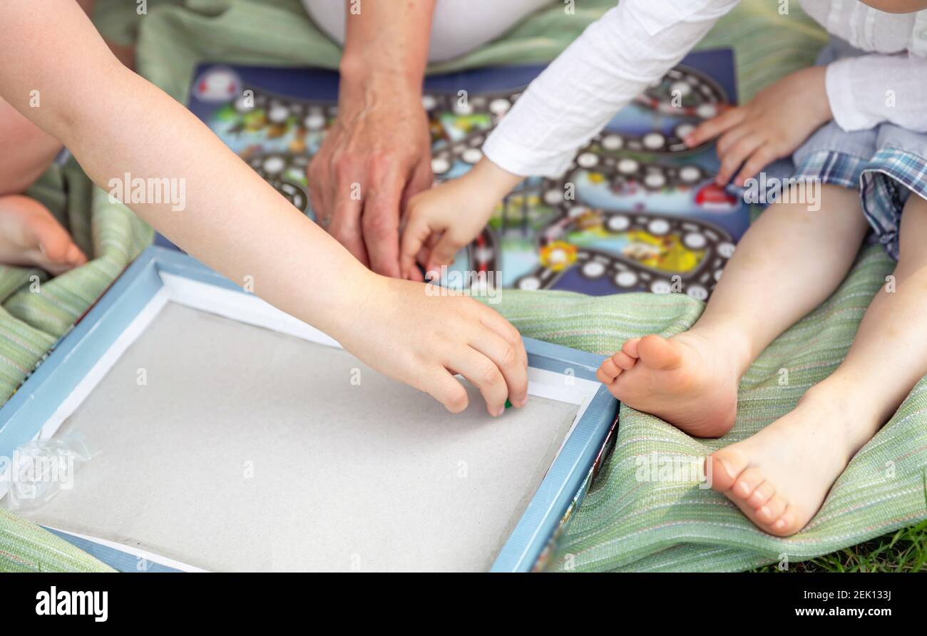 Selektiver Fokus der Familie spielen Brettspiel im Park. Kindheit Stockfoto
