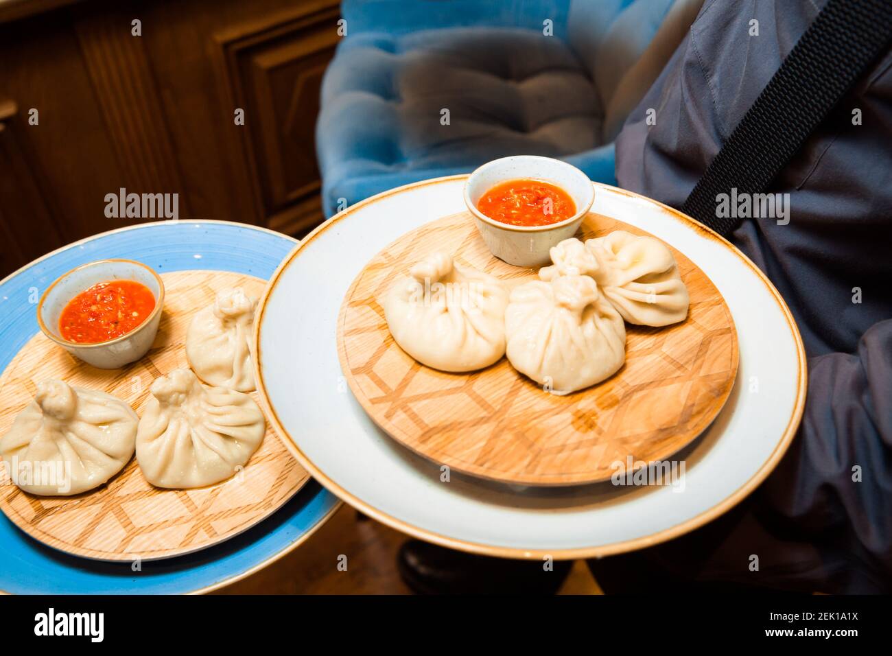 Saftige Khinkali auf einem weißen Teller. Serviert mit Sauce. Traditionelles Gericht. Stockfoto