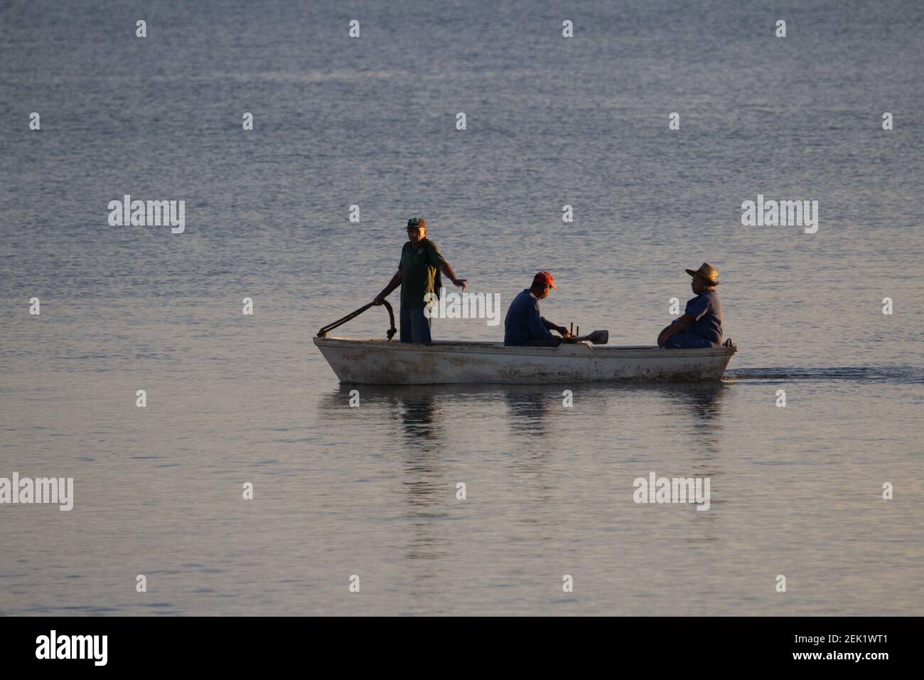 HOLGUIN, KUBA - FEBRUAR 15; 2019 3 Männer in einem kleinen Ruderboot im Morgenlicht Stockfoto
