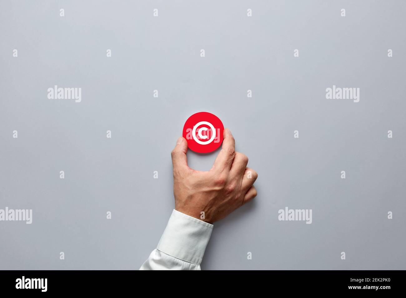 Geschäftsmann Hand mit einem roten Abzeichen mit Copyright-Symbol. Schutzrechte und Markenpatentschutz im Geschäftskonzept. Stockfoto
