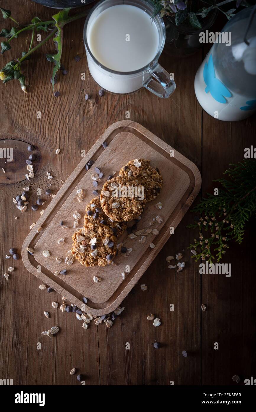 Haferflocken Schokolade Chip Cookie mit Glas Milch. Gesunde Kekse auf natürlichem Holzhintergrund. Stockfoto