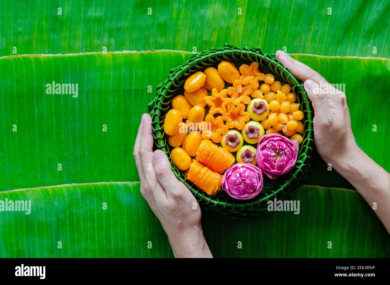 Hand halten Thai Hochzeit Desserts auf Bananenblatt Teller oder krathong für thai traditionelle Zeremonie auf Bananenblatt Hintergrund. Stockfoto