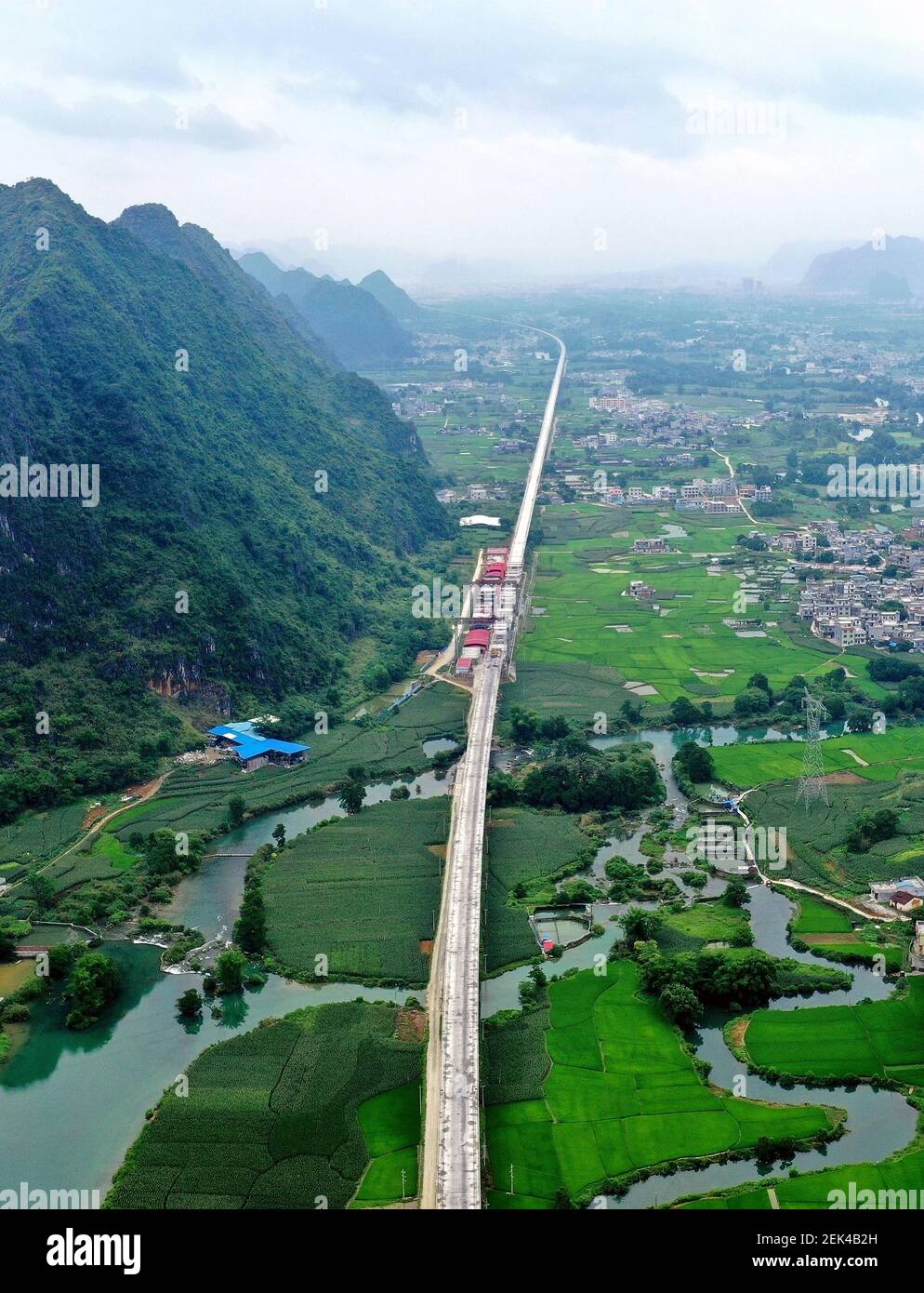 HECHI, CHINA - 31. MAI 2020 - Luftaufnahme der Chengjiang-Doppelgleis-Super-Major-Brücke im Bau über dem ländlichen Gebiet des Autonomen Landkreises Guangxi Du'an Yao. Hechi, Guangxi, China, 31. Mai 2020. Die Gesamtlänge der Brücke beträgt 15,5km, die längste der bestehenden Eisenbahnbrücken in Guangxi. (Foto von Gao Dongfeng / Costfoto/Sipa USA) Stockfoto