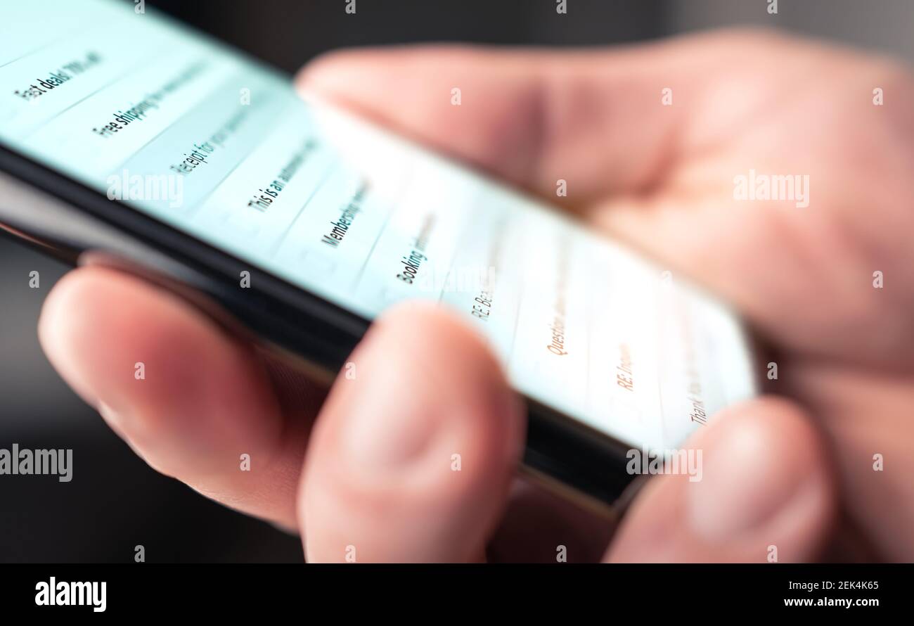 E-Mail-Posteingang im Telefon. Liste der neuen ungelesenen Nachrichten. Mann mit Blick auf digitale mobile Mail-Konto mit Smartphone. Marketing-Newsletter und Spam. Stockfoto