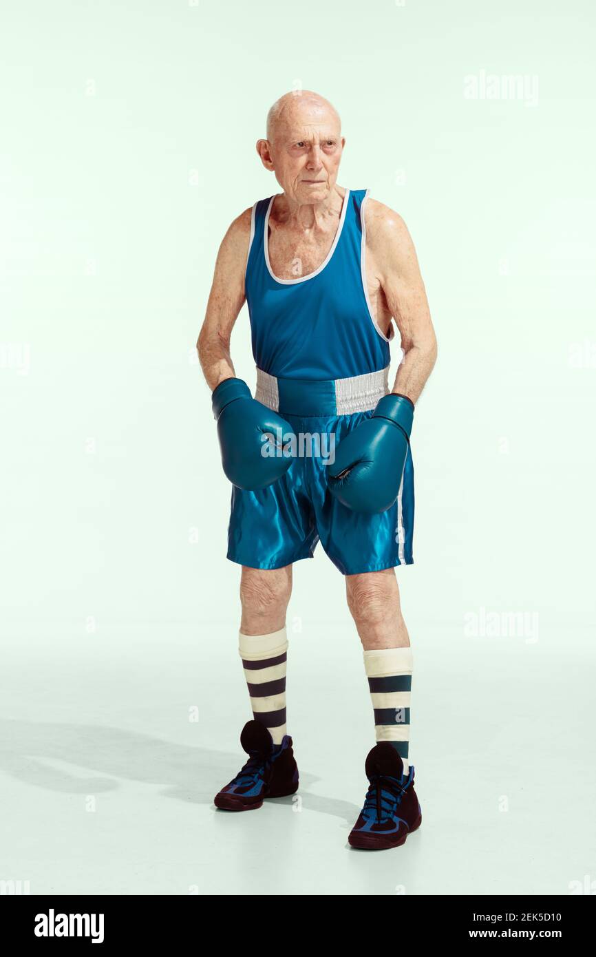 Senior Mann trägt Sportbekleidung Boxen isoliert auf Studio Hintergrund. Kaukasisches männliches Modell in guter Form bleibt aktiv und sportlich. Konzept von Sport, Aktivität, Bewegung, Wohlbefinden. Copyspace, Anzeige. Stockfoto