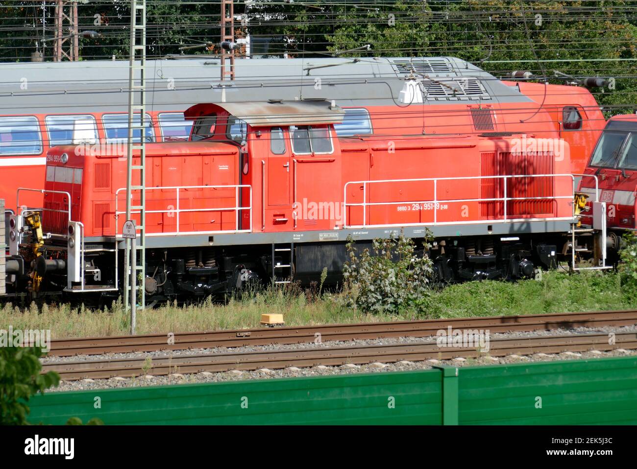 Rote Diesellokomotive, Nahverkehrszüge, Bahnanlagen, grüne Lärmschutzmauer, Bremen, Deutschland Stockfoto
