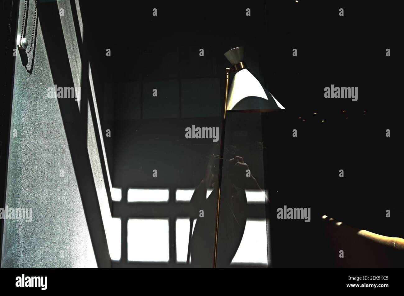 Spiegelung des selbst, das ein Foto in einem Fenster zwischen Licht und Schatten in London macht Stockfoto