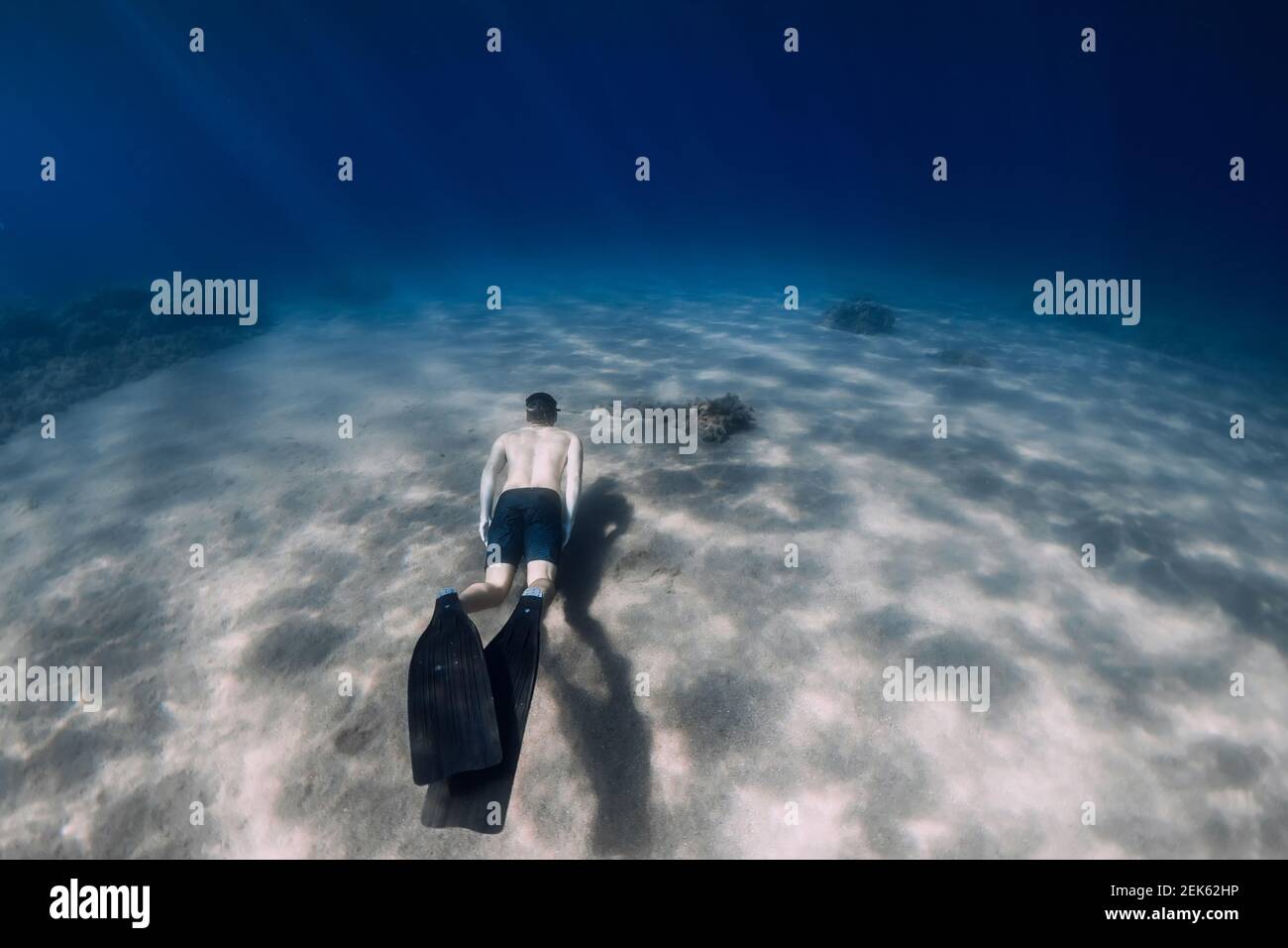Sportlicher Mann Freitauchgang mit Flossen, unter Wasser im tropischen Meer. Stockfoto