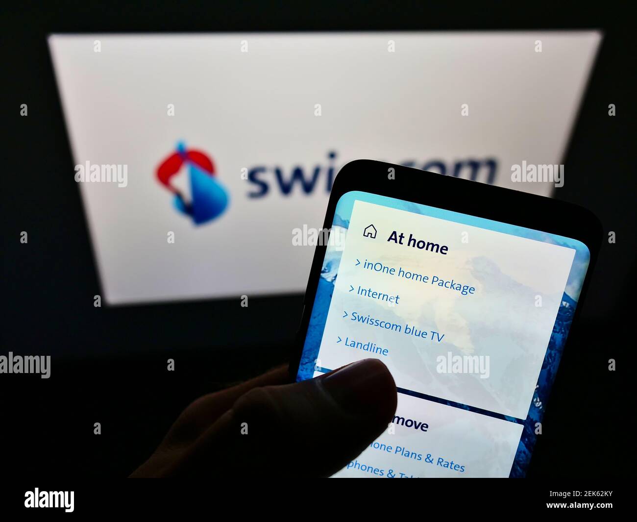 Person mit Mobiltelefon mit Logo des Schweizer Telekommunikationsunternehmens Swisscom AG auf dem Bildschirm mit Webseite. Konzentrieren Sie sich auf die obere linke Seite des Telefondisplays. Stockfoto