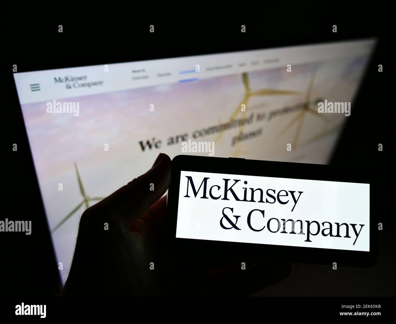 Person, die Mobiltelefon mit dem Logo des Unternehmensberatungsunternehmens McKinsey Company auf dem Bildschirm vor der Webseite hält. Fokus auf Handy-Display. Stockfoto