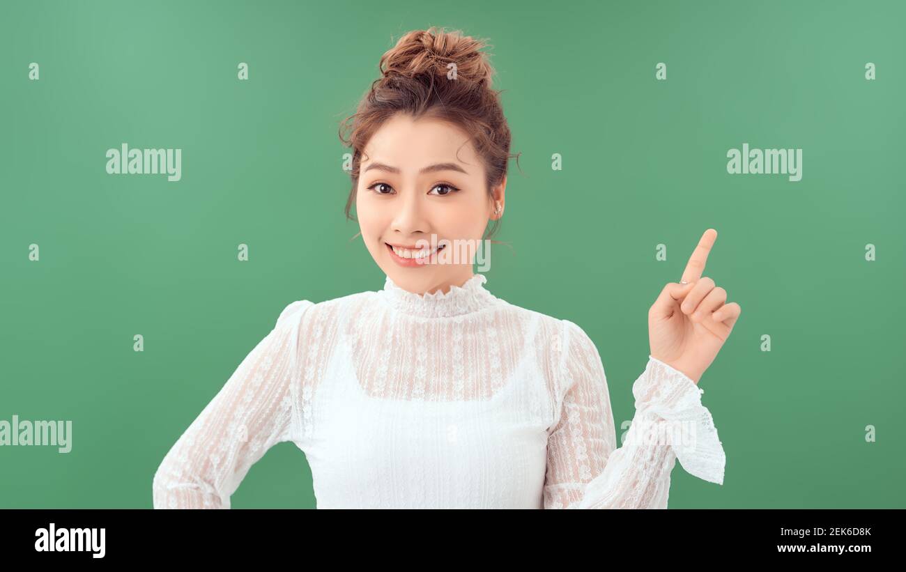 Portrait der positiven fröhlichen Frau Promoter Hand halten präsentieren Anzeigen promo-Objekt auf grünem Hintergrund Stockfoto