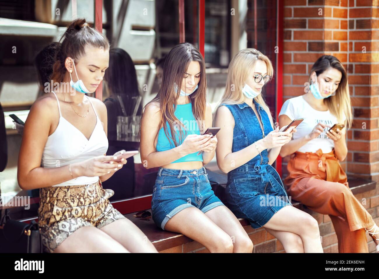 Städtische immune junge Menschen mit offenem Gesicht Maske mit mobilen Telefone im Freien Stockfoto