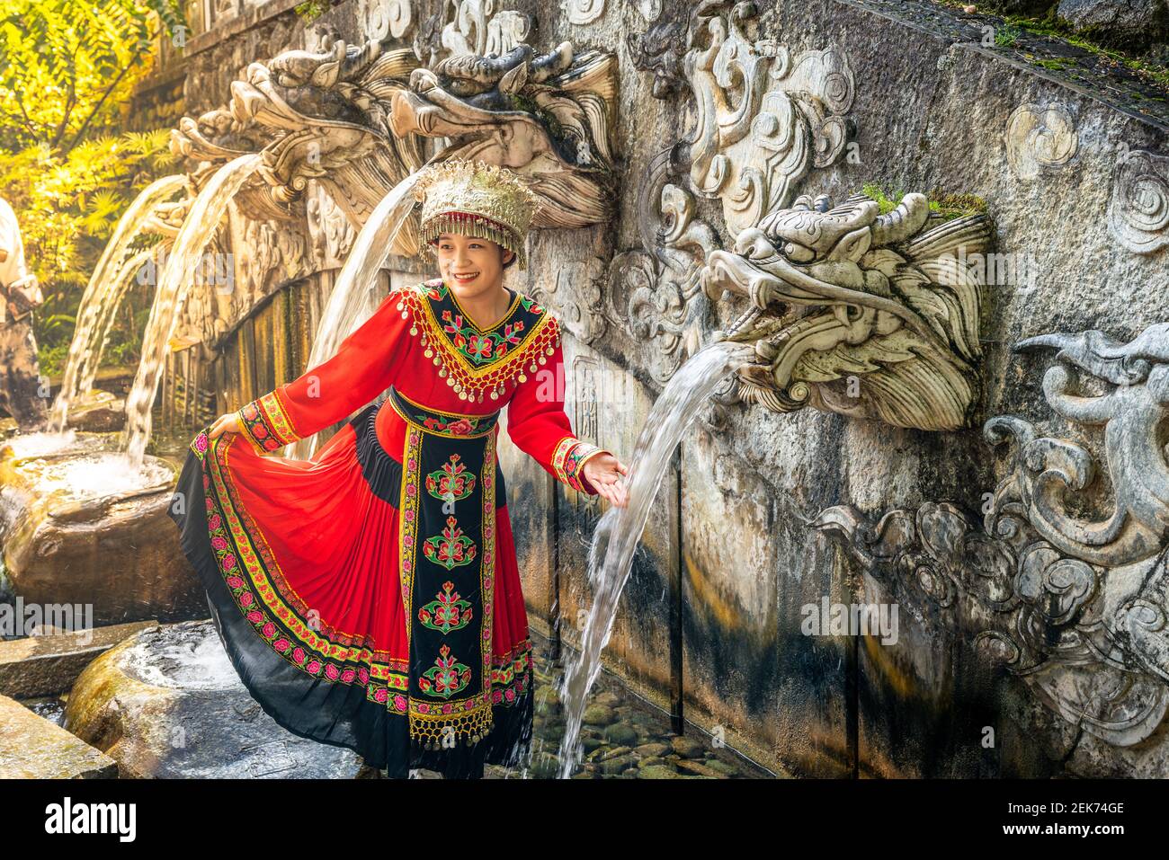 Dali China , 6 Oktober 2020 : Frau in Bai Minderheit traditionelle ethnische Kleidung vor den fünf Drachen Pool Brunnen im Schmetterling Frühling Park i Stockfoto
