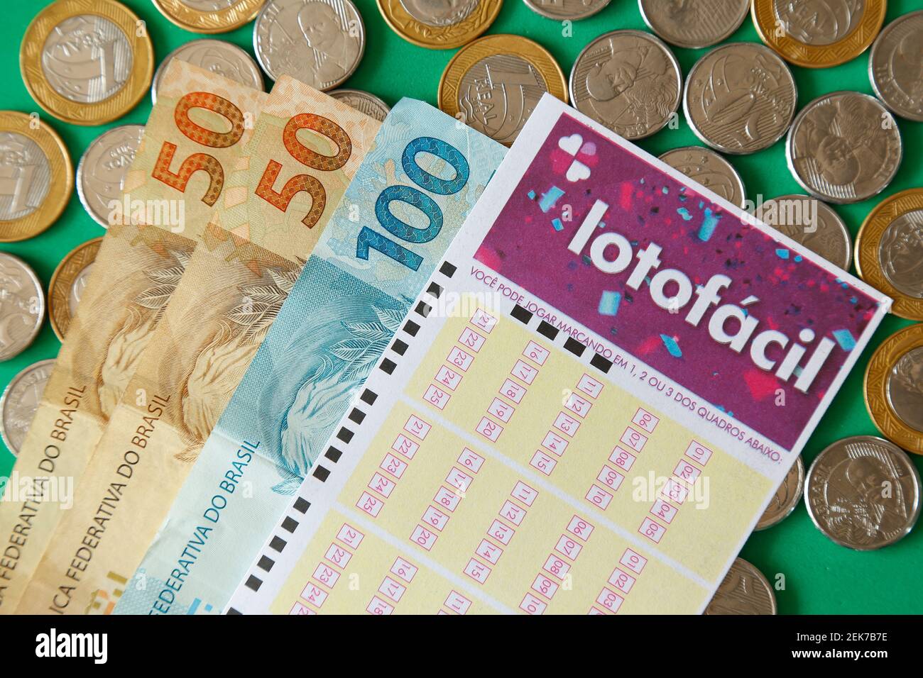 Minas Gerais, Brasilien - 22. Februar 2021: Geldscheine, Münzen und Lottoschein Caixa Lotofacil Stockfoto