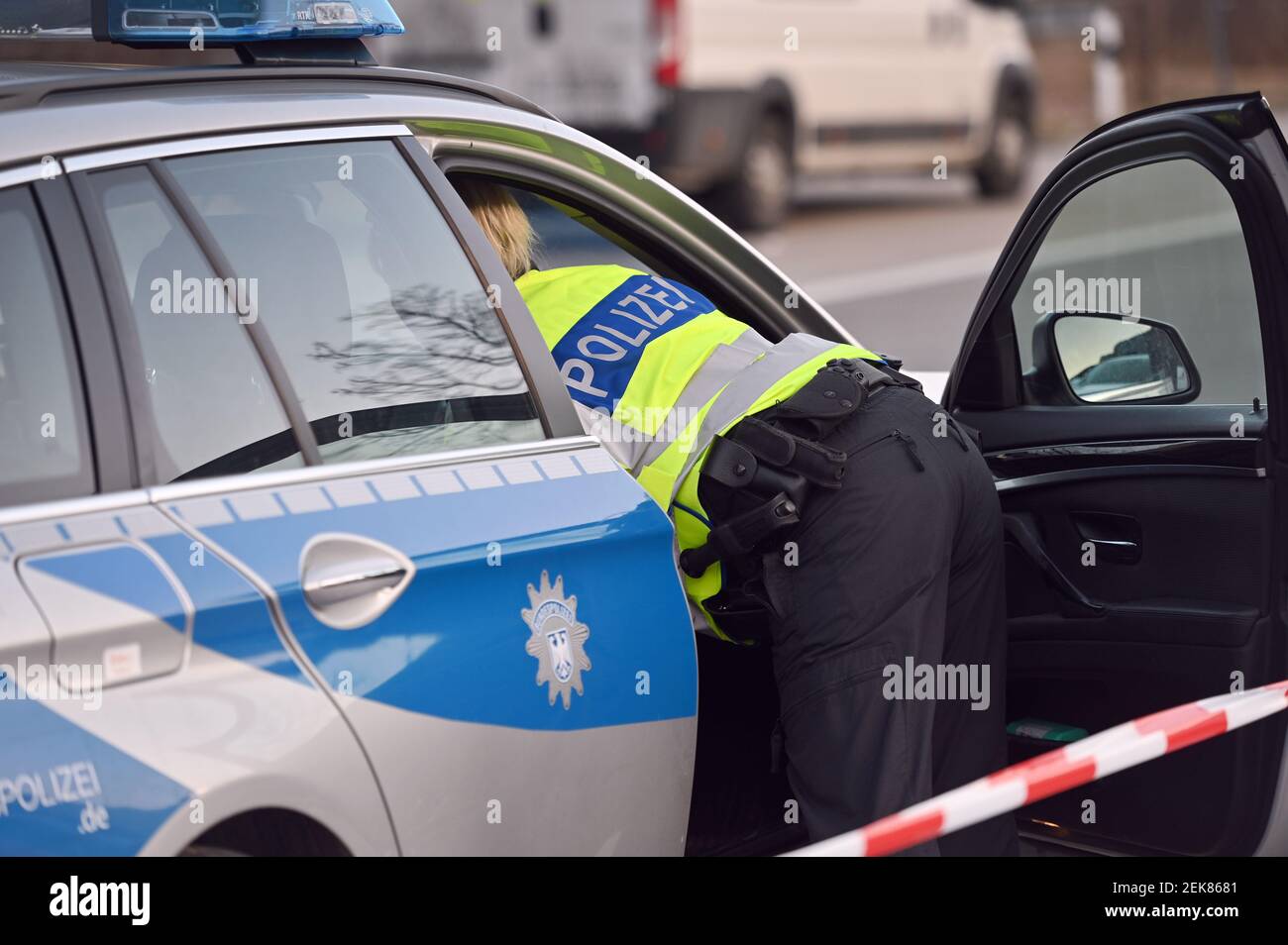 Grenzkontrollen an der österreichisch-deutschen Grenze, Grenzübergang Kiefersfelden Grenzpolizisten kontrollieren Autofahrer, die von Tirol/Österreich nach Bayern/Deutschland einreisen. Polizistin mit gelben Schutzwesten lehnt sich in ein Polizeiauto, weltweit Stockfoto