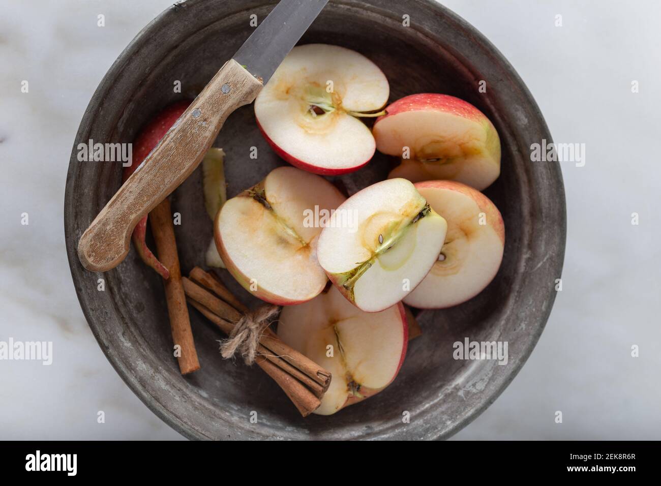 Frisch geschnittene Äpfel mit Zimtstangen auf Marmorboden. Draufsicht. Stockfoto