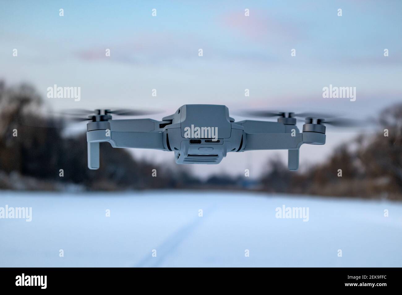 Kharkiv, Ukraine - 21. Februar 2021: DJI Mavic Mini 2 Drohne fliegen im  Winter verschneite Landschaft in lila Sonnenuntergang bewölkten Himmel.  Neuer Quadcopter-Gerät Hover Stockfotografie - Alamy