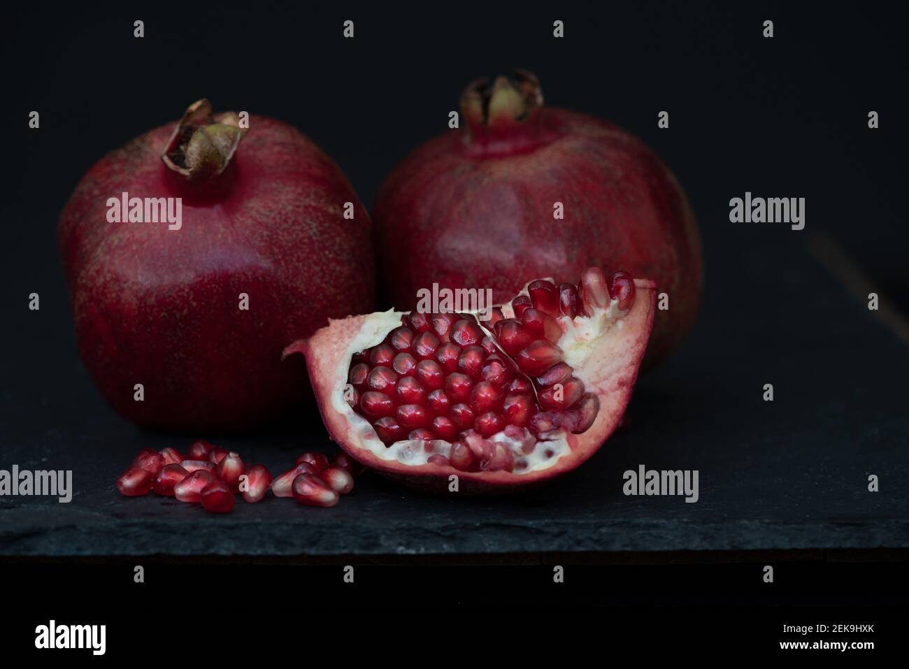 Zwei Granatapfel Obst, eine ganze und eine offene, gegen Holz- Tabelle, Ansicht von oben - gesunde ernährung Konzept Stockfoto